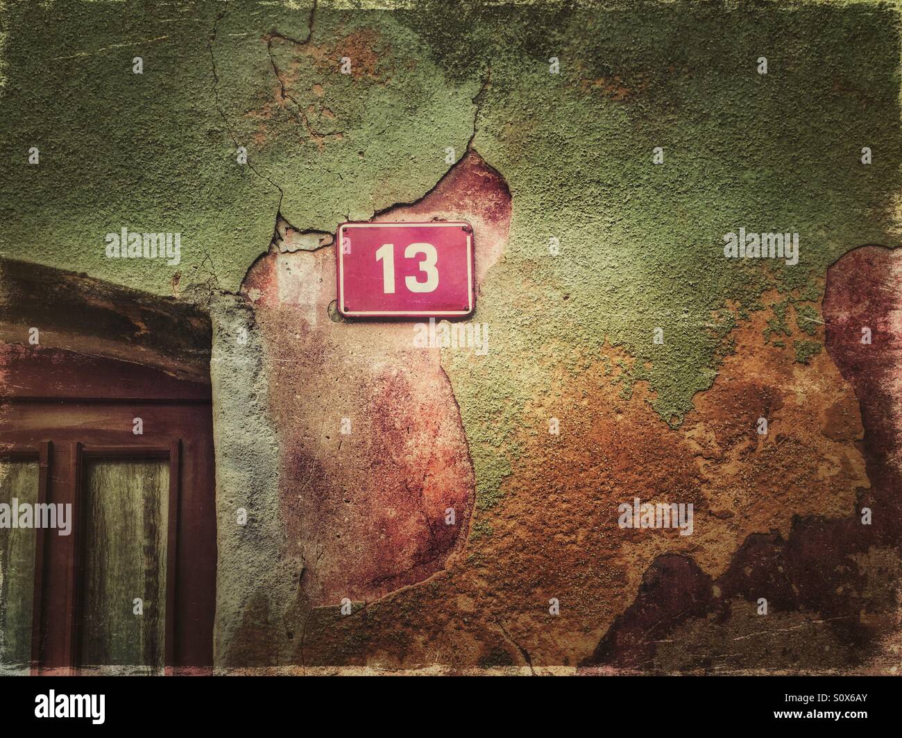 House number 13 on a peeling colorful facade - Smartphone Captured Stock Image