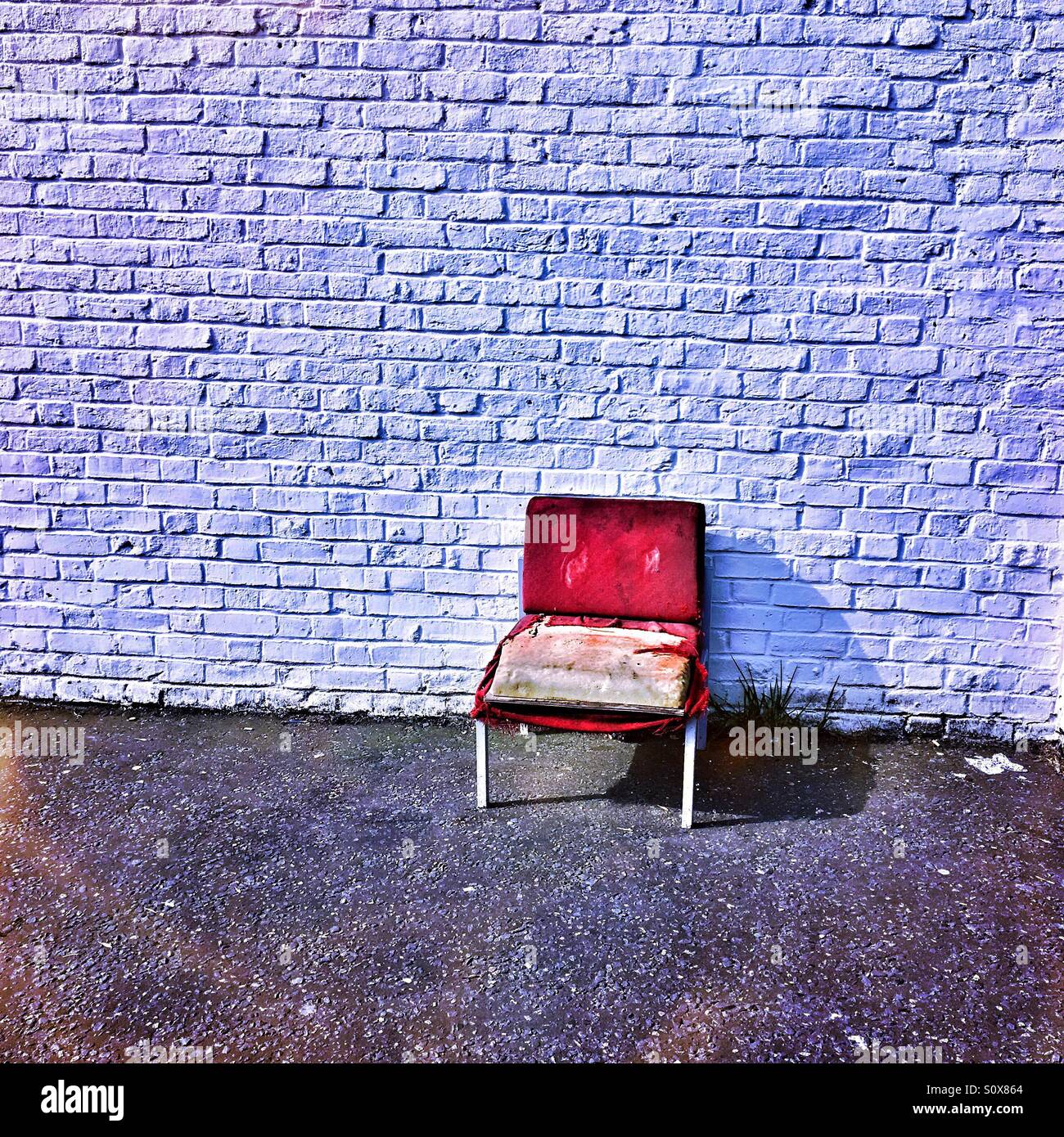Old chair against a wall Stock Photo Alamy