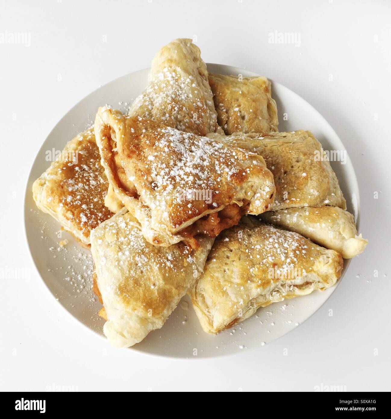 Freshly baked apple turnover pastries on a white plate. - Smartphone Captured Stock Image