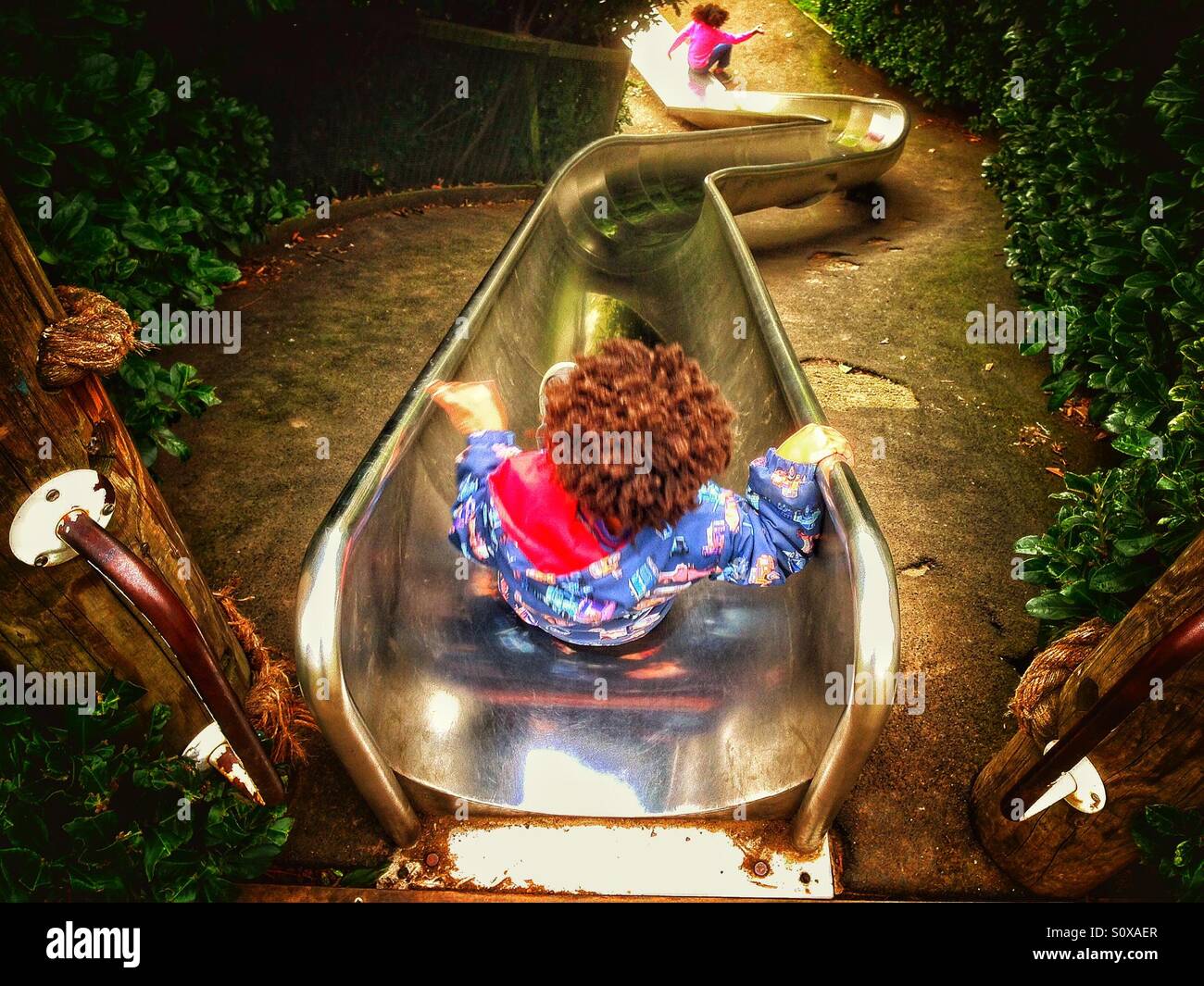Two children on a slide. - Smartphone Captured Stock Image