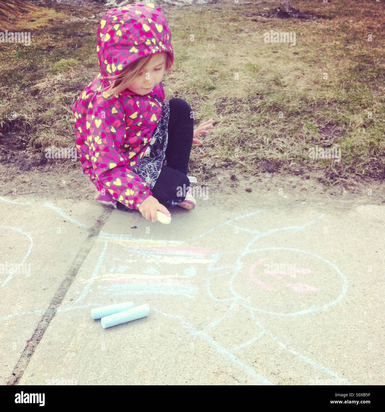Young girl drawing with chalk on sidewalk Stock Photo - Alamy