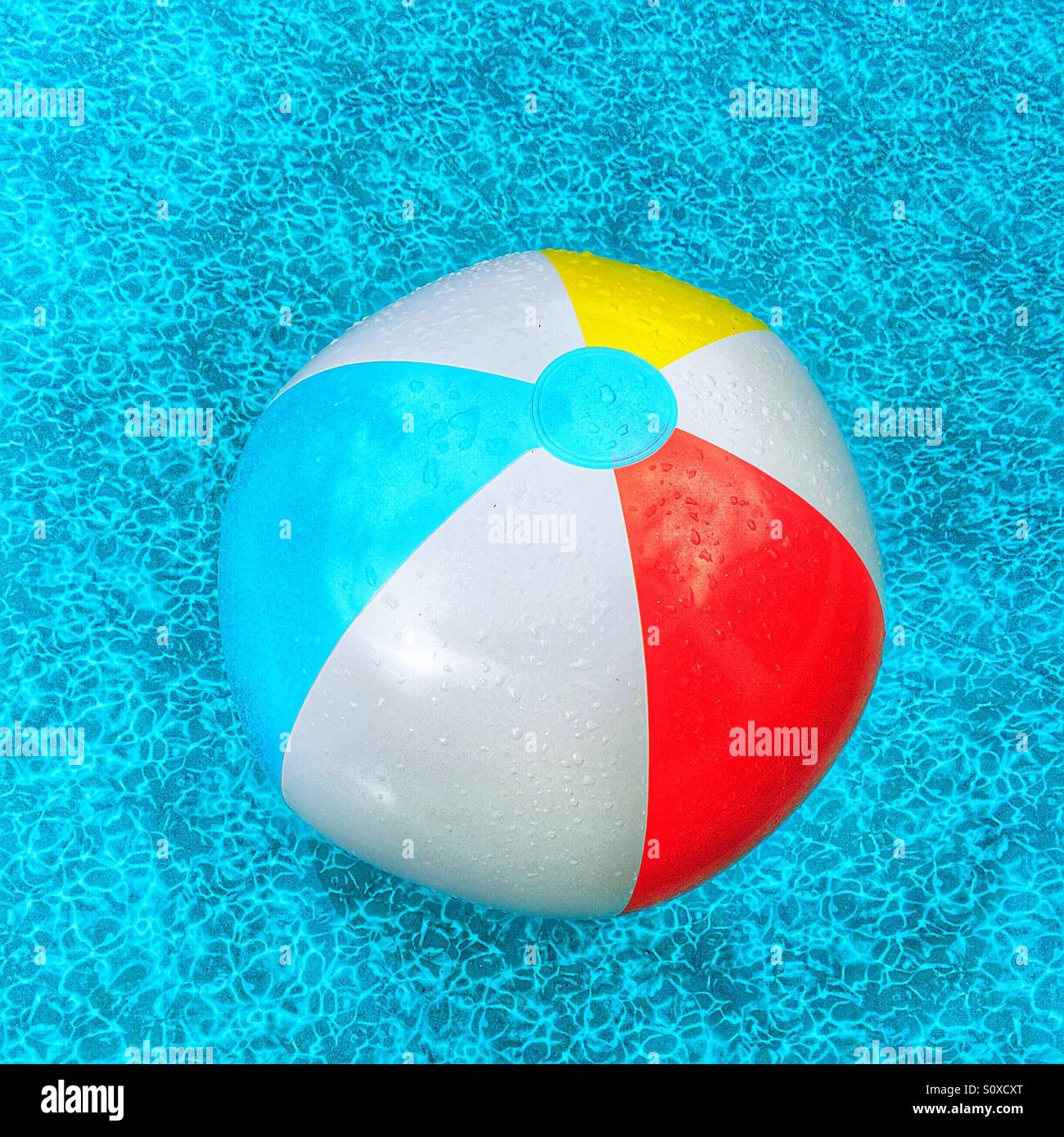 Beach ball floating in the waters of a swimming pool - Smartphone Captured Stock Image