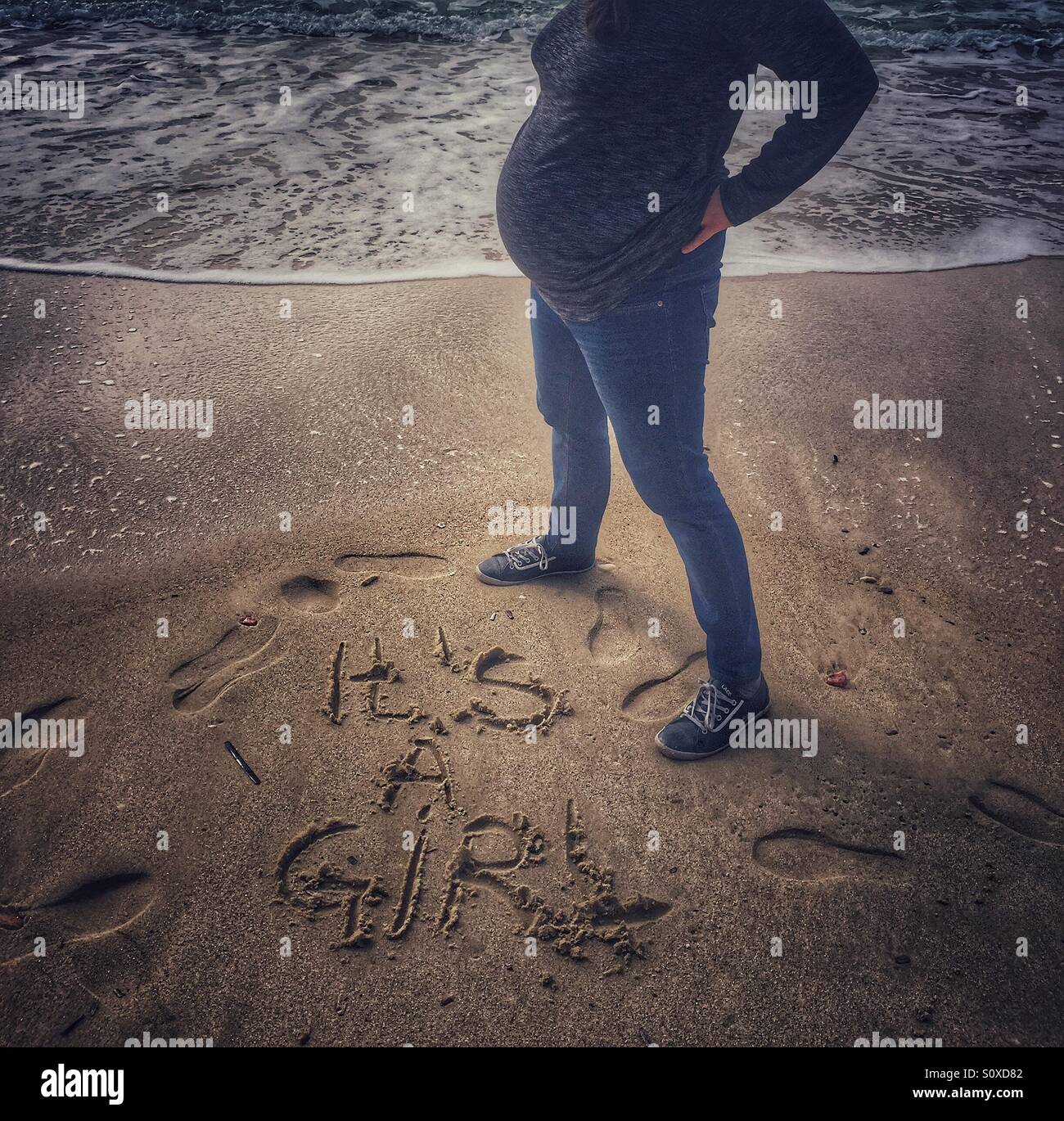 Pregnant woman announce on the beach Stock Photo