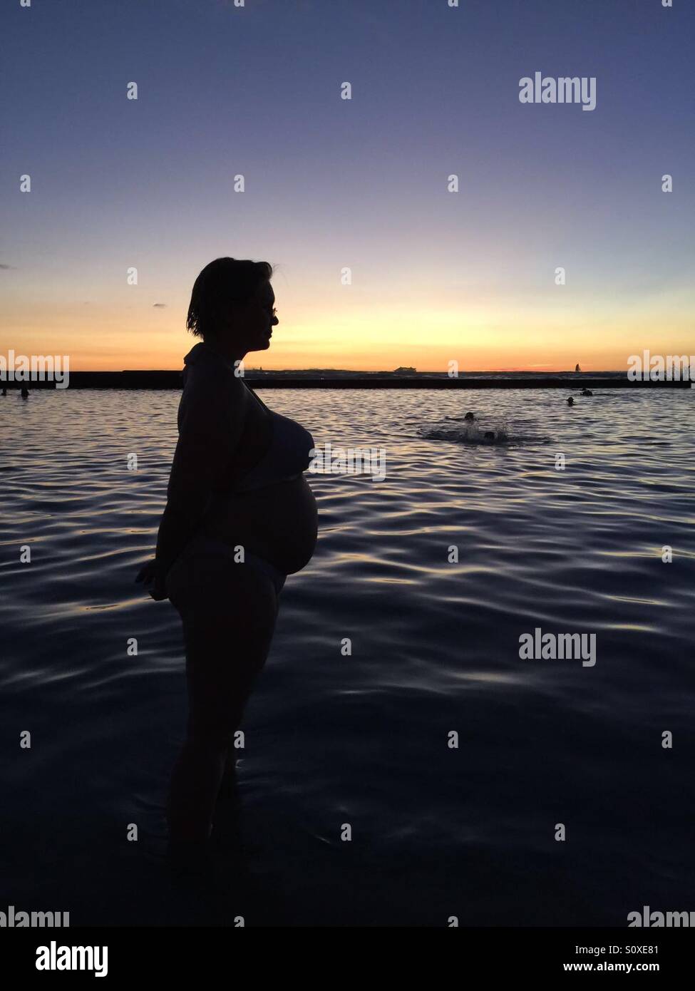 Pregnant woman in the sunset on a beach Stock Photo