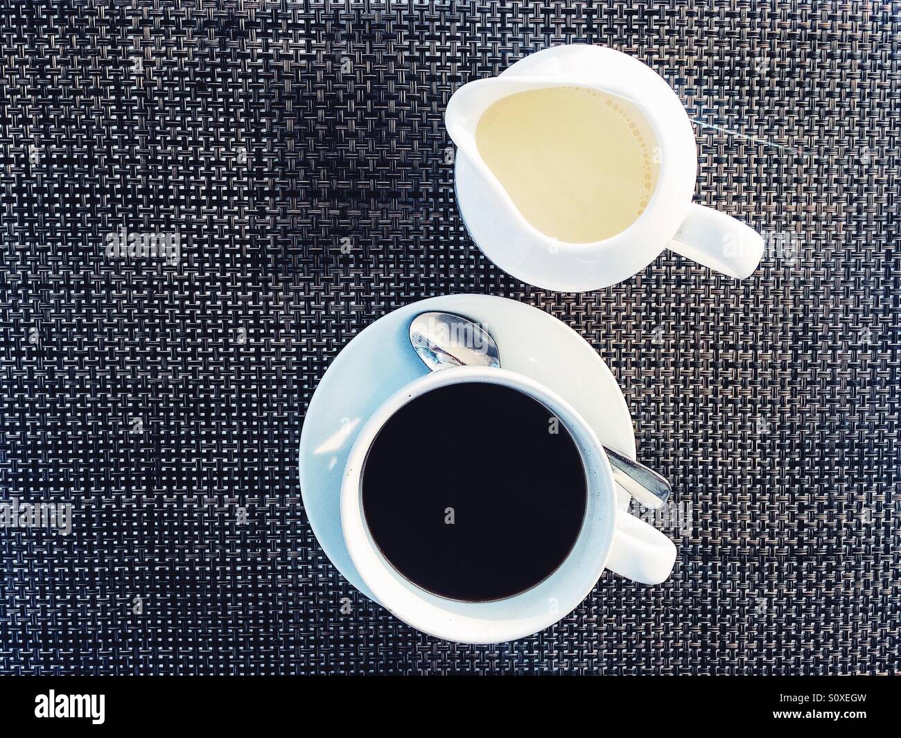 Black coffee and white milk on a black and white surface Stock Photo