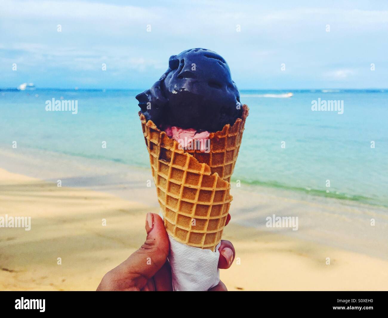 Woman holding an ice cream at the beach Stock Photo