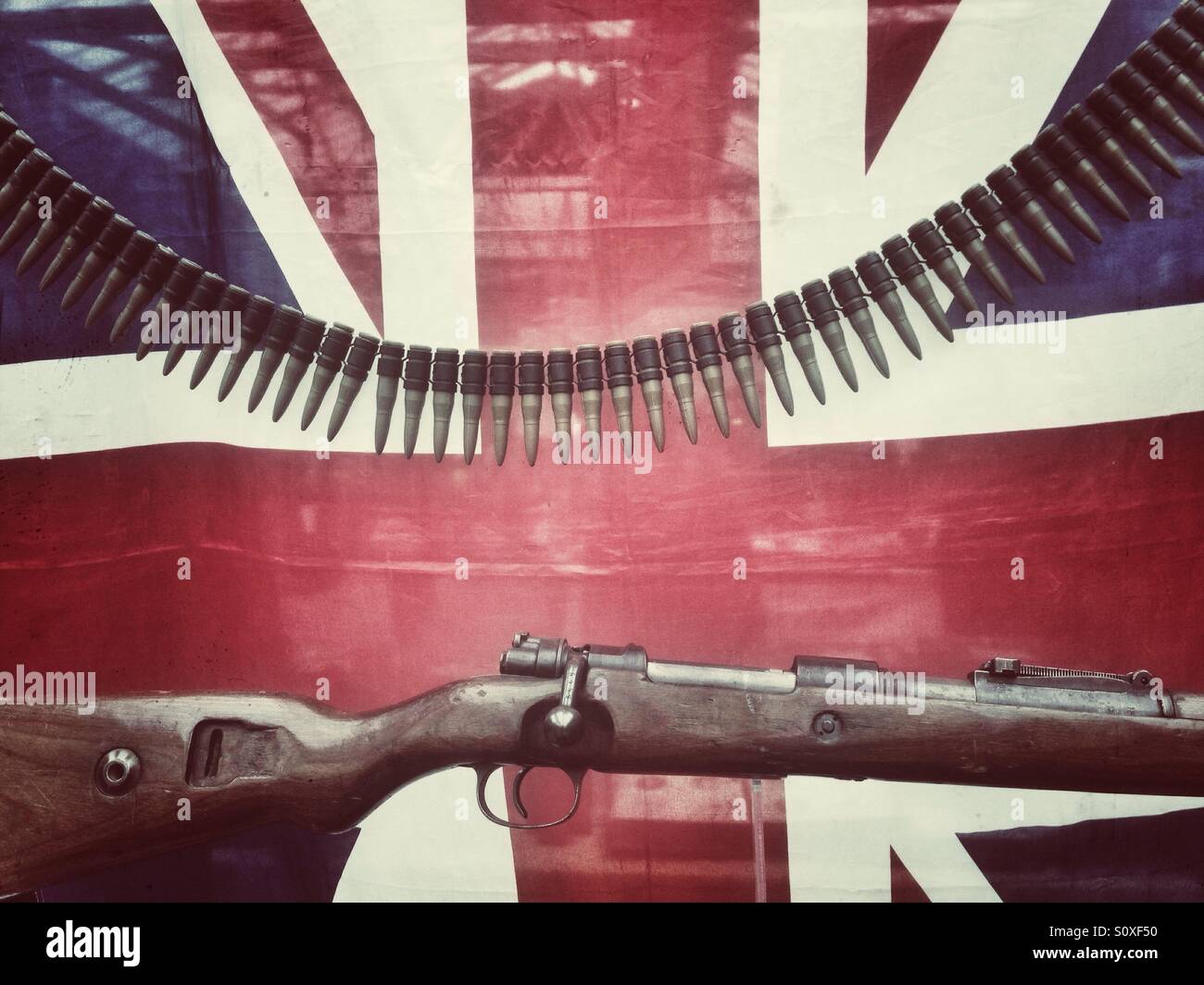 A military rifle and ammunition in front of a union jack - Smartphone Captured Stock Image