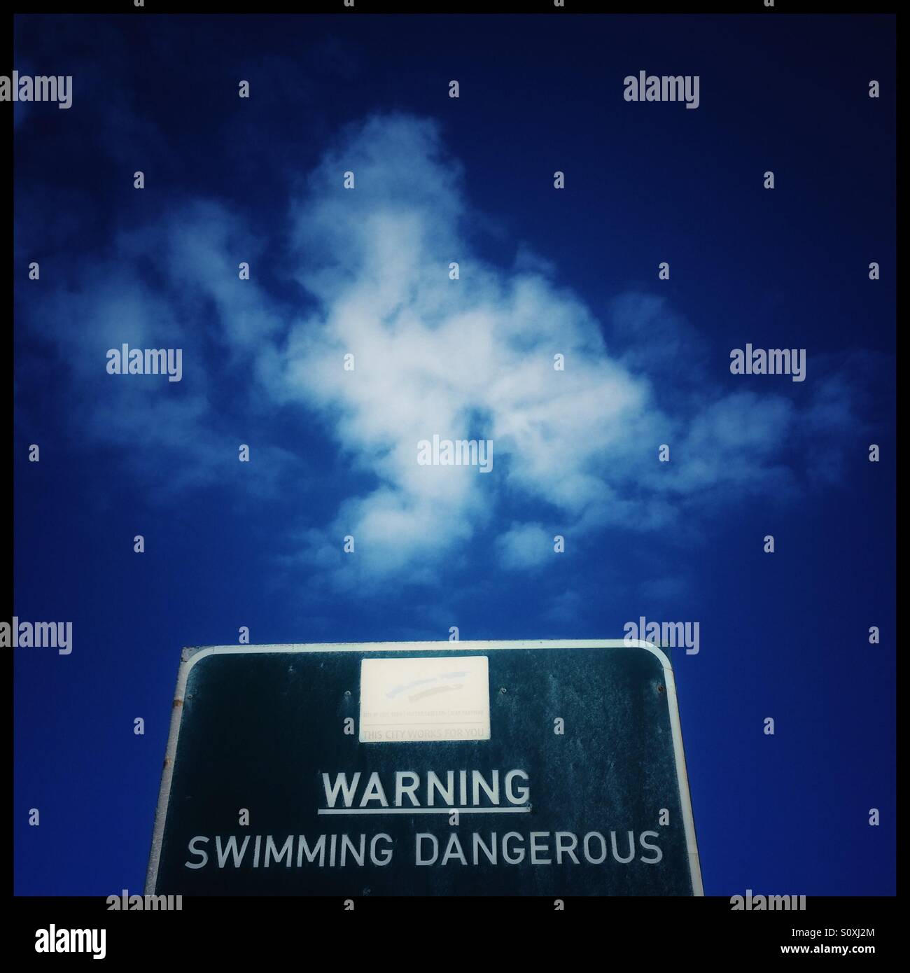Warning swimming dangerous sign  at Bloubergstrand beach near Cape Town, South Africa. - Smartphone Captured Stock Image
