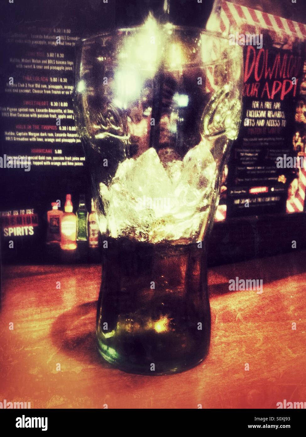 A glass containing mostly ice after the cola has been drunk. - Smartphone Captured Stock Image