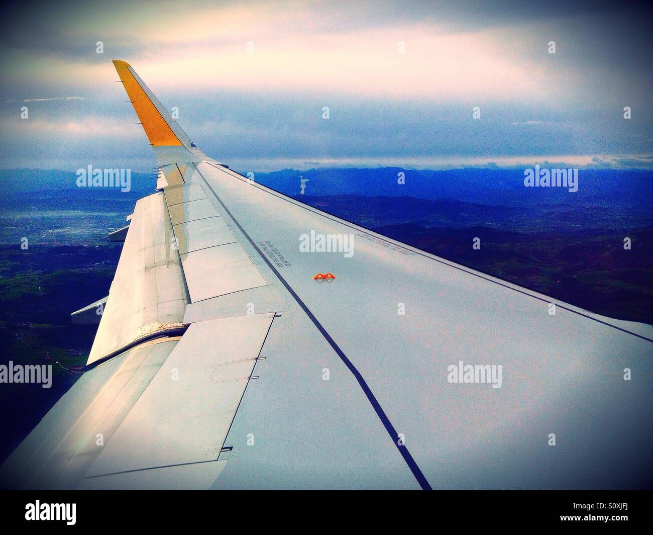 View of an airplane over the clouds from the window - Smartphone Captured Stock Image