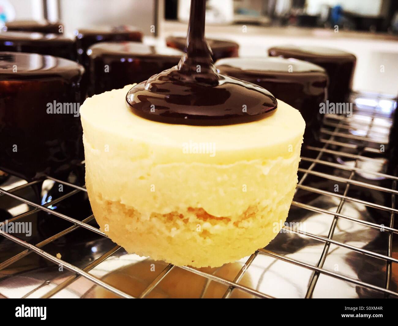 Pouring chocolate glaze on mousse cake Stock Photo