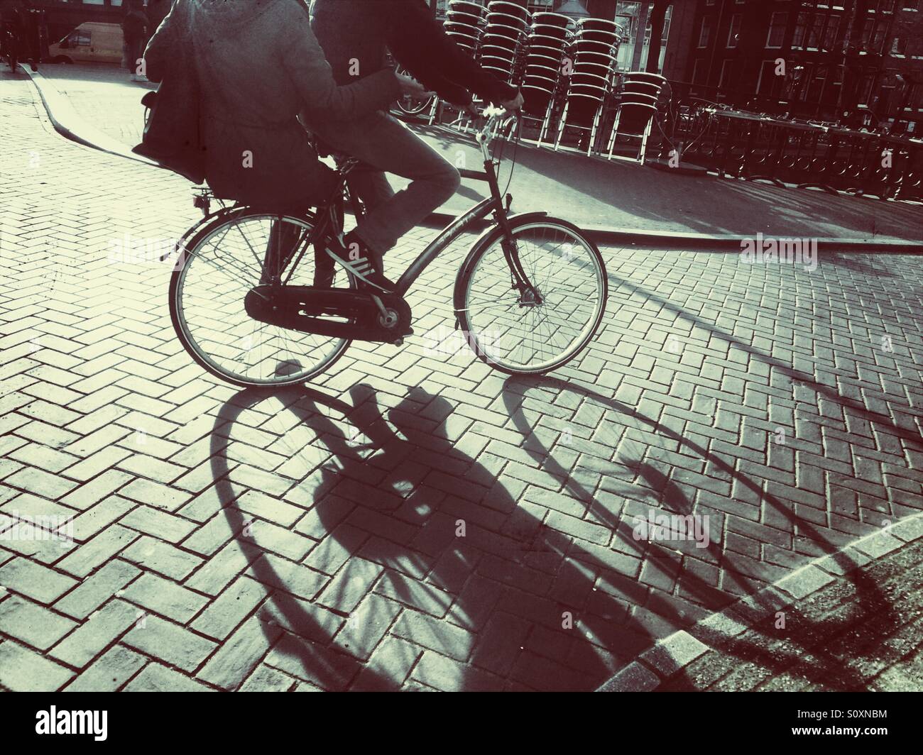 Couple riding a bike in Amsterdam, The Netherlands - Smartphone Captured Stock Image