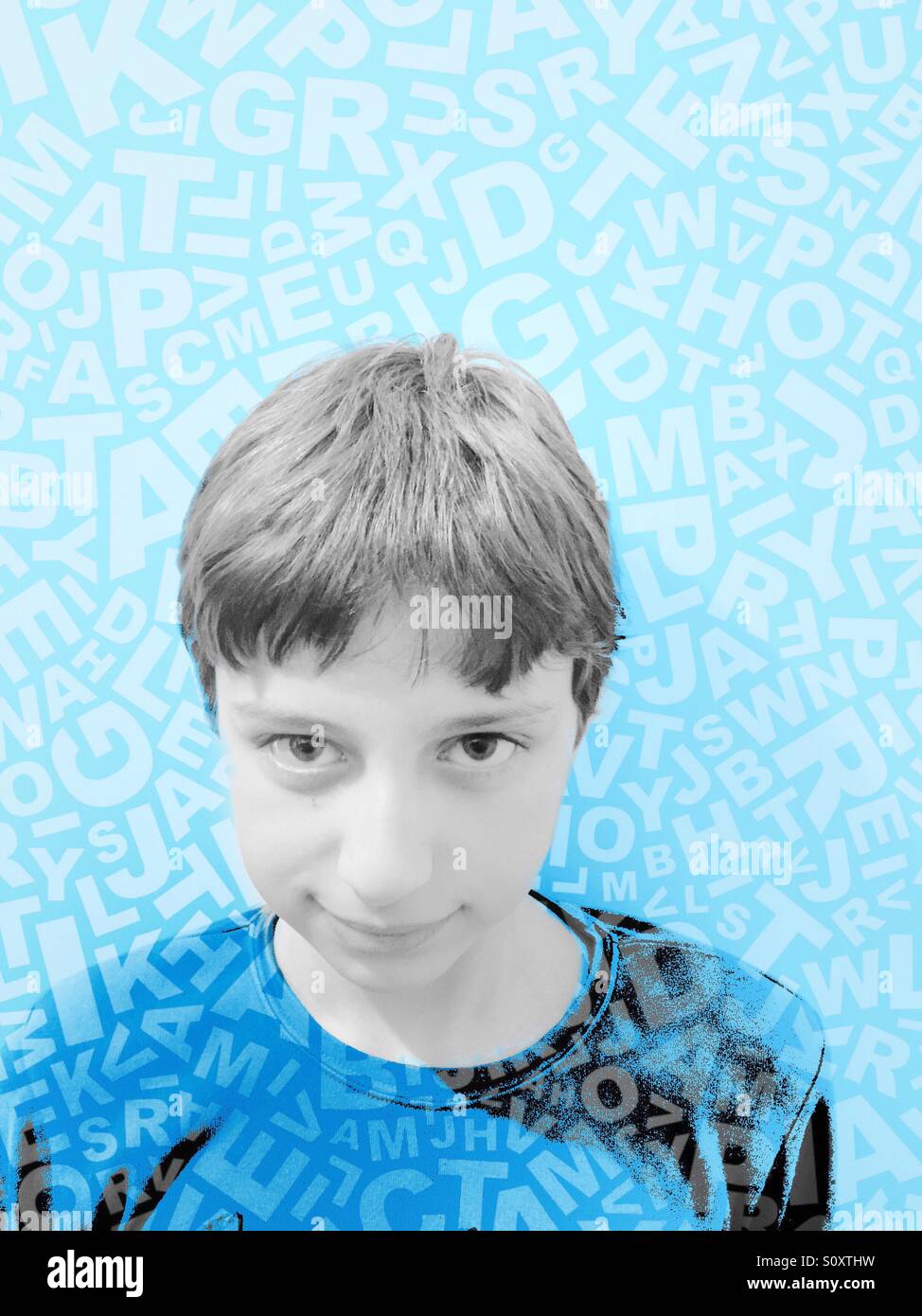 Portrait of a smiling boy surrounded by artistically placed letters. - Smartphone Captured Stock Image