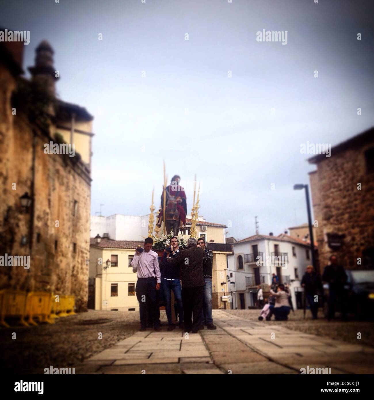 Men carry a throne with a sculpture of Jesus Christ riding a donkey used to celebrate Palm Sunday during Easter in Plasencia, Caceres, Extremadura, Spain - Smartphone Captured Stock Image