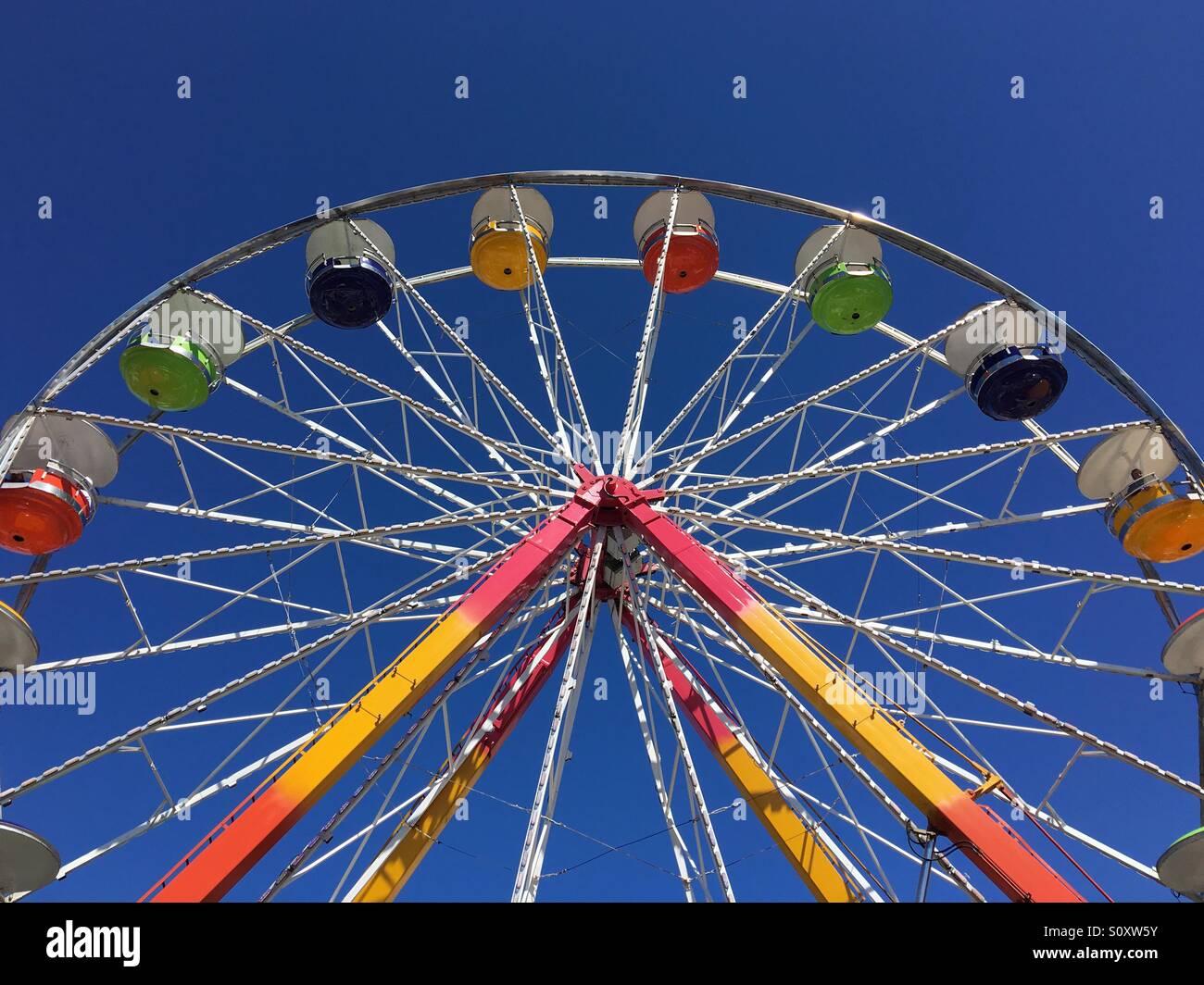 Low angle view of a Ferris wheel against a clear blue sky - Smartphone Captured Stock Image