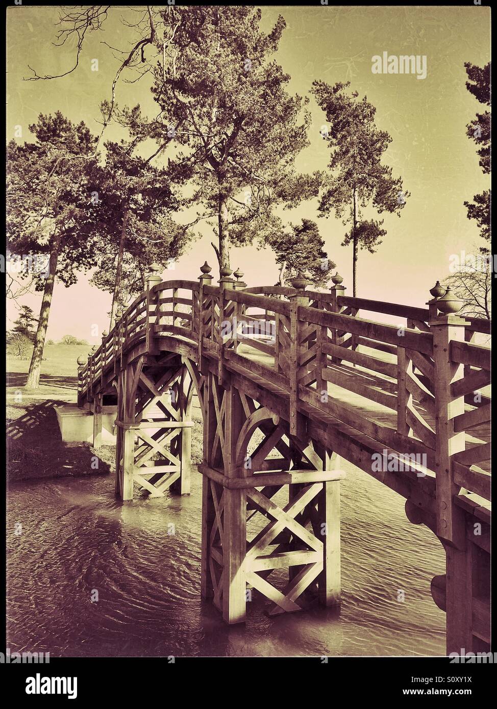 An antique effect picture, of a newly constructed bridge crosses a river in a parkland, somewhere in England. Photo Credit - © COLIN HOSKINS. - Smartphone Captured Stock Image