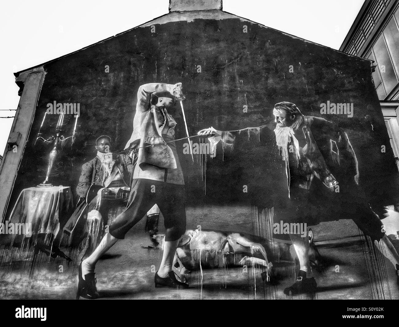 A monochrome mural on the gable wall of The Black Box Performance & Arts Venue in Hill Street, Cathedral Quarter, Belfast, Northern Ireland. The picture depicting two men duelling. © COLIN HOSKINS. Stock Photo