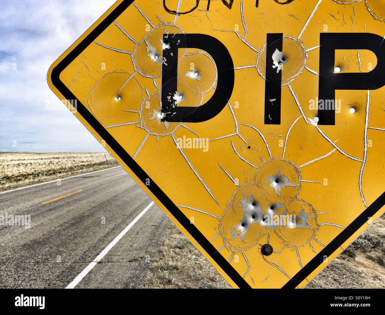 Close-up of bullet ridden dip warning sign Stock Photo - Alamy