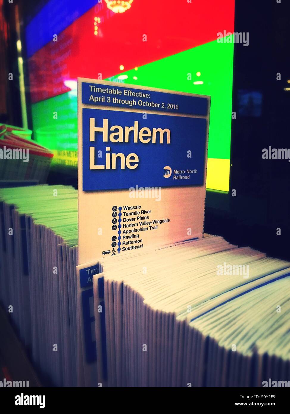 Timetable pamphlet of the Harlem line of Metro-North Railroad at the information kiosk at Grand Central terminal, New York City - Smartphone Captured Stock Image