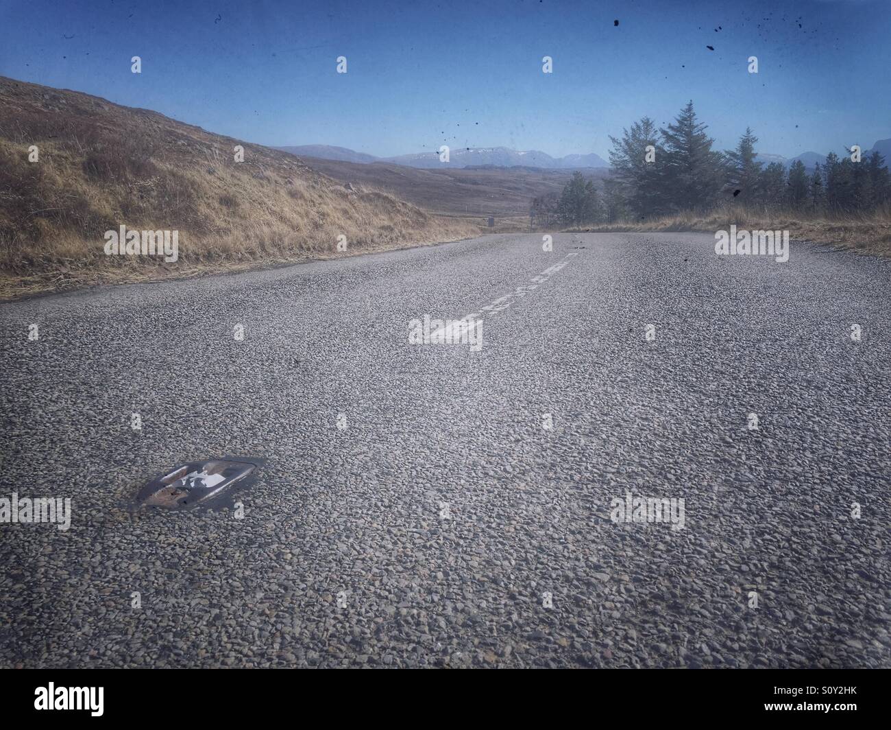Mountain road vanishes around a corner, Scotland, UK - Smartphone Captured Stock Image