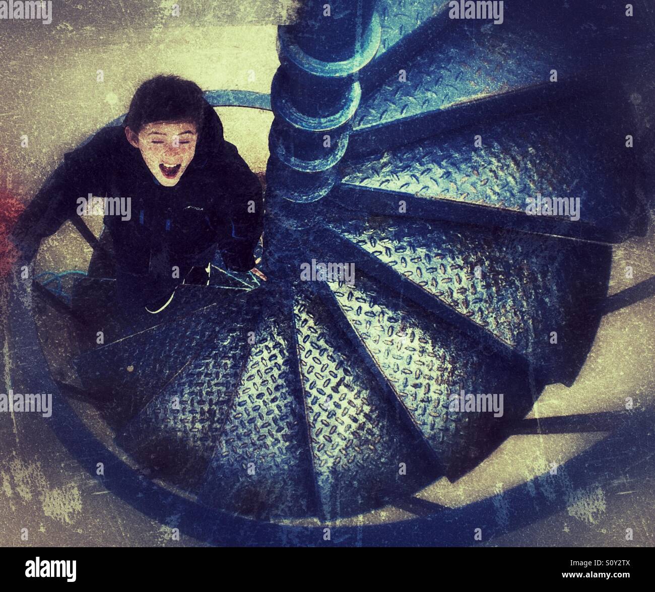 Eyes shut. Young boy walking up metal steps . Stock Photo