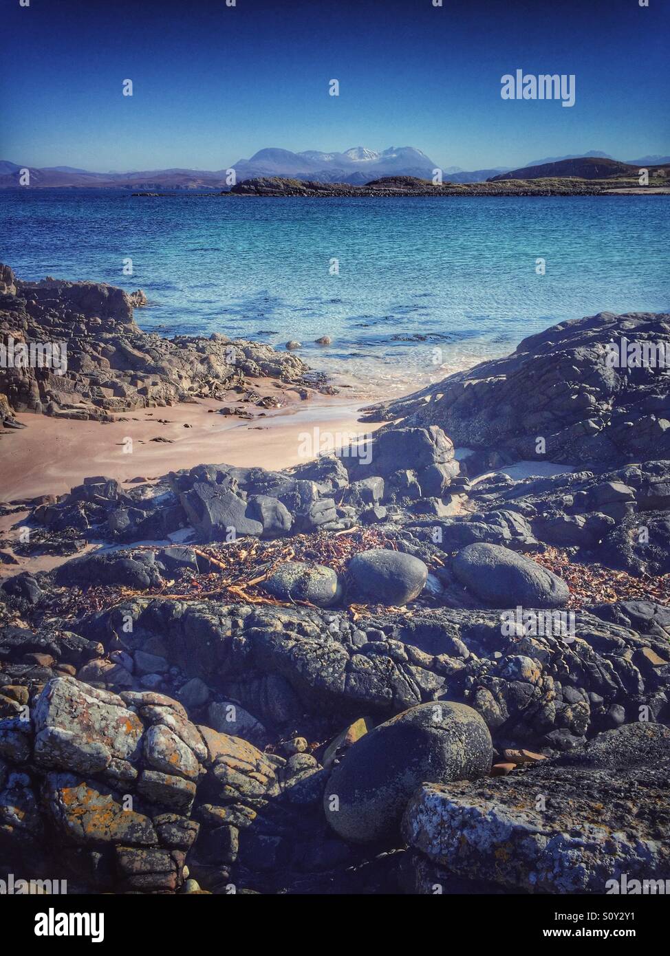 Sandy beach, rocks and crystal clear water at Achnasheen in the Scottish highlands - Smartphone Captured Stock Image