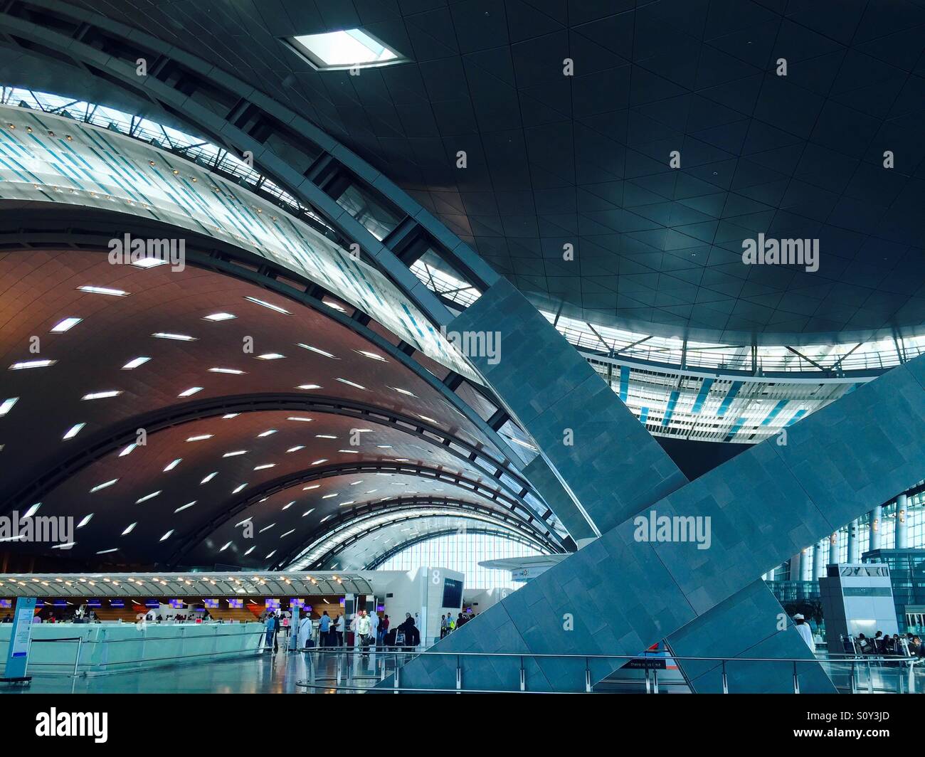 The striking, curving architecture of Hamad International Airport, Doha, Qatar is designed to represent ocean waves and sand dunes - a fundamental aspect of the nation's rich cultural heritage. - Smartphone Captured Stock Image