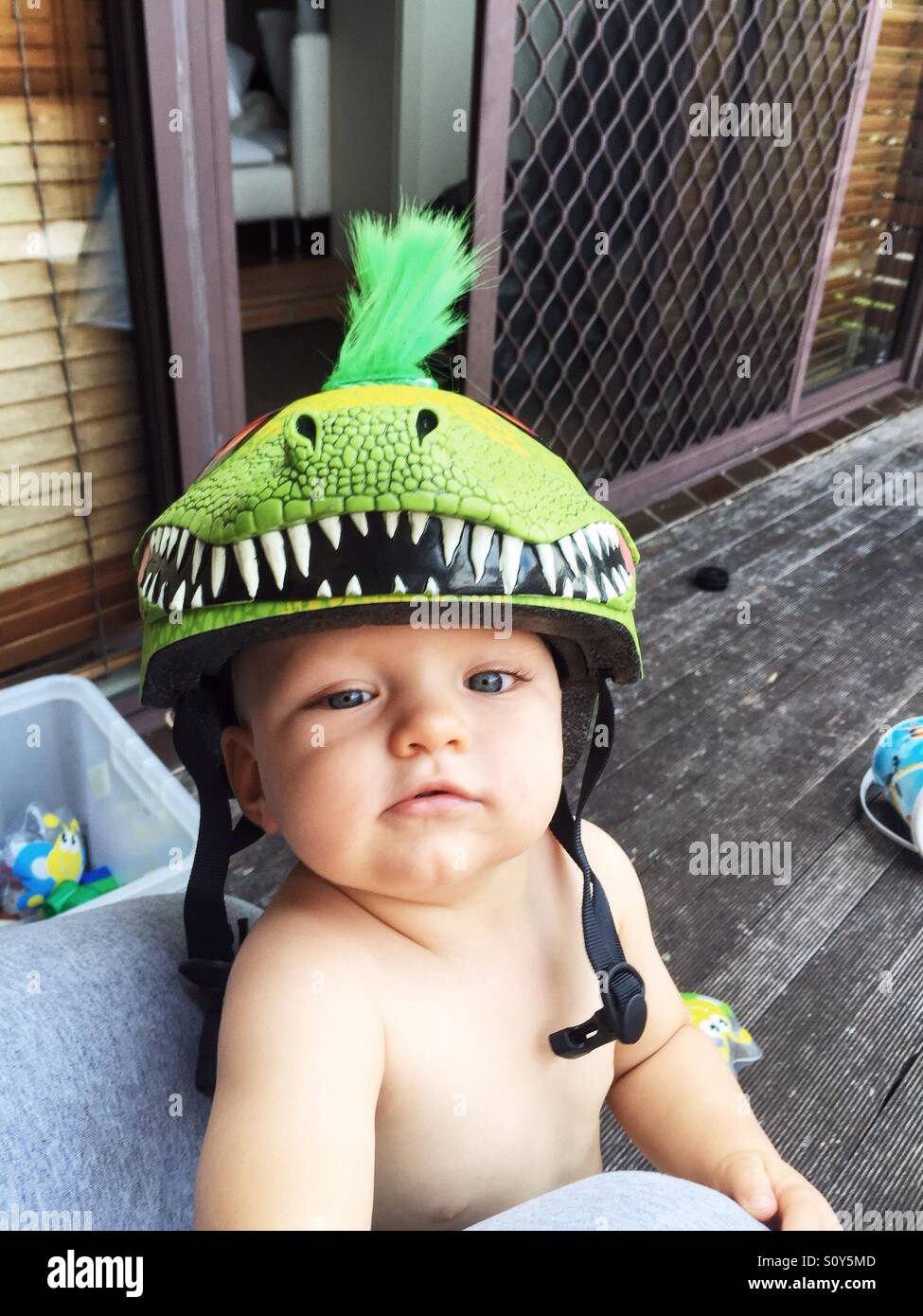 Cute little boy with his dinosaur helmet on Stock Photo