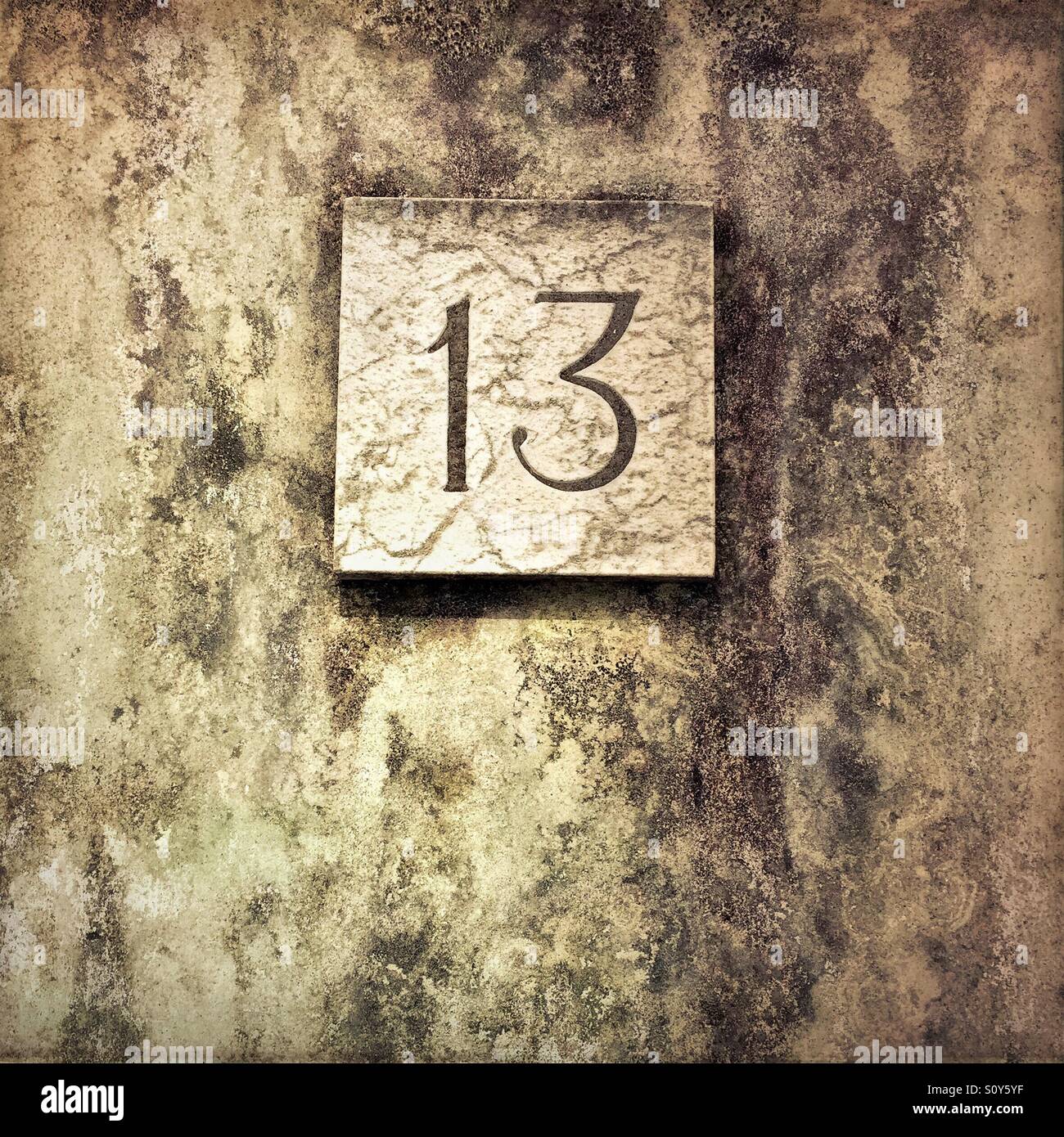 House number 13 on a dirty wall - Smartphone Captured Stock Image