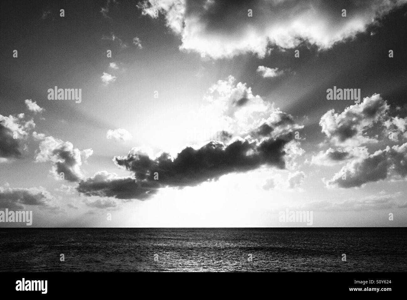 Black and white image sunlight behind clouds over the horizon - Smartphone Captured Stock Image