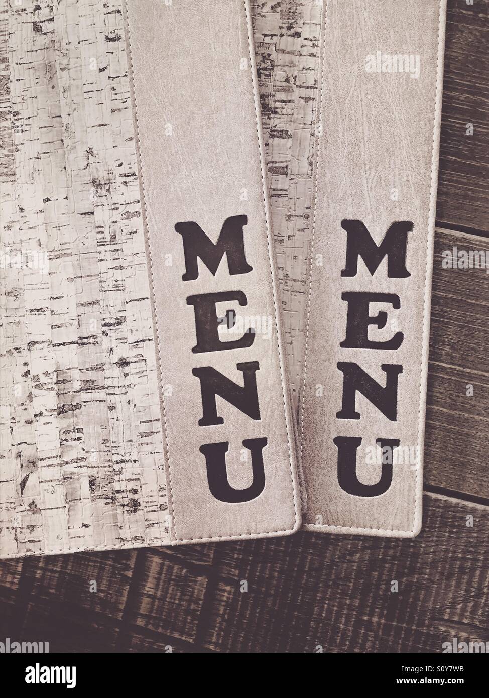 Closed menu books on a wooden table - Smartphone Captured Stock Image