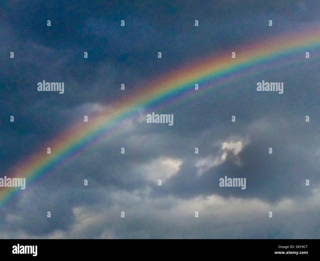 Rainbow in blue sky Stock Photo - Alamy
