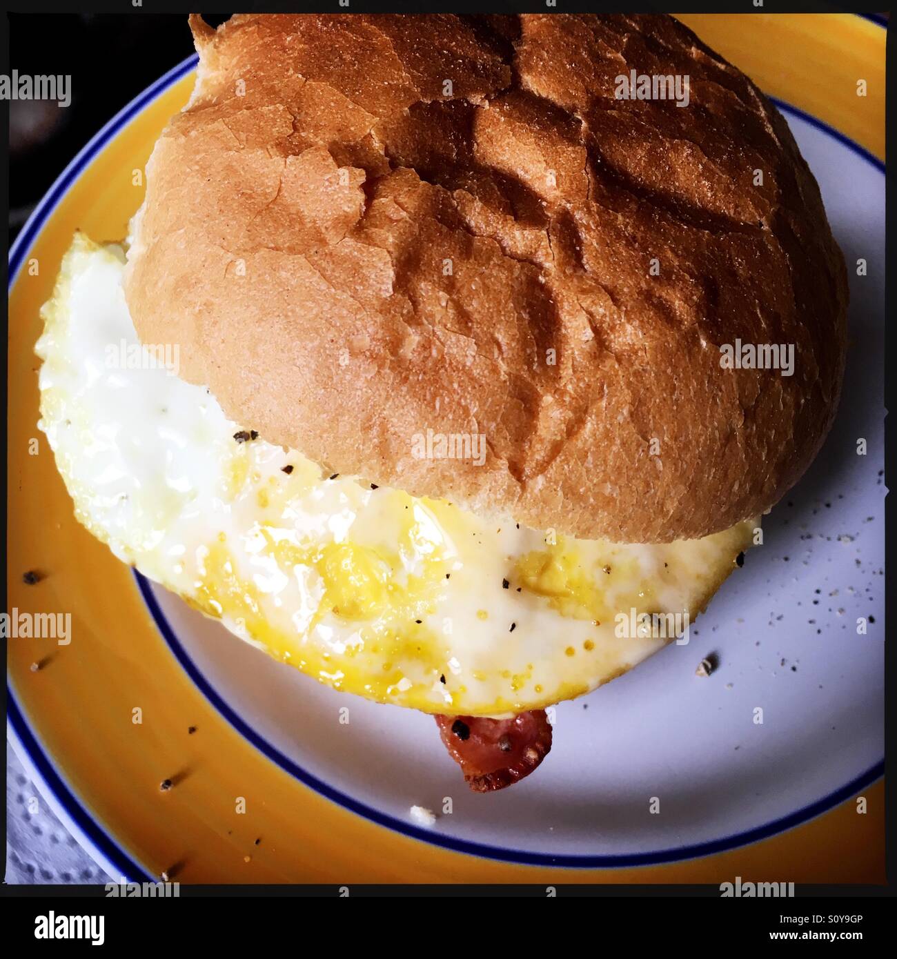 Egg and bacon roll on a plate Stock Photo