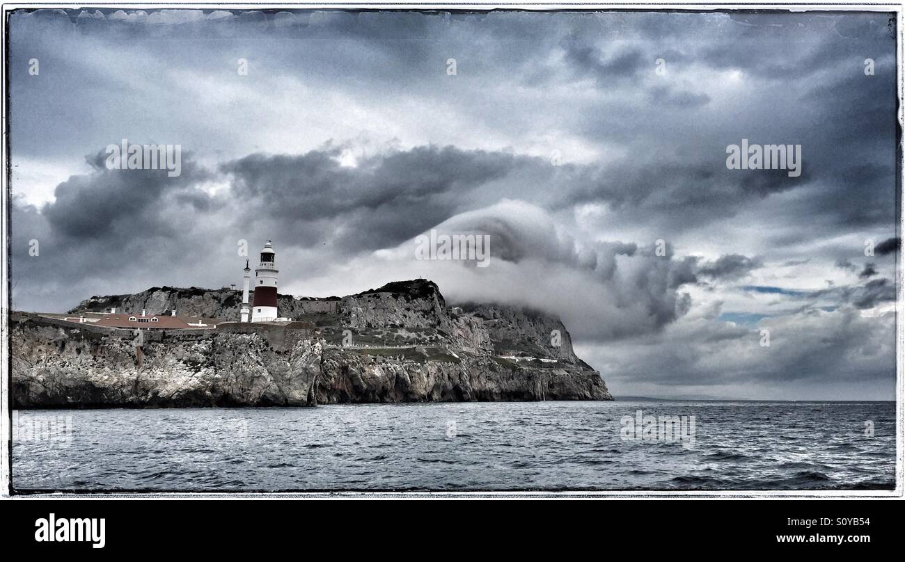Europa Point lighthouse Gibraltar with clouds swirling around the rock, from sea Stock Photo