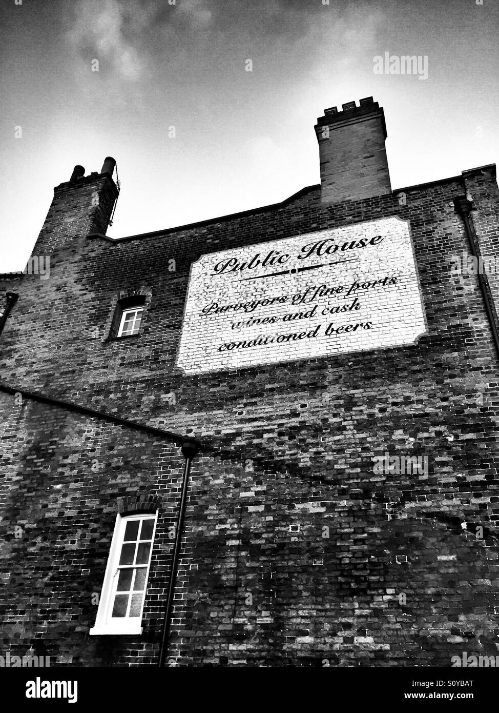Old brick wall with a traditional hand painted sign. Ware, Hertfordshire, U.K. Stock Photo