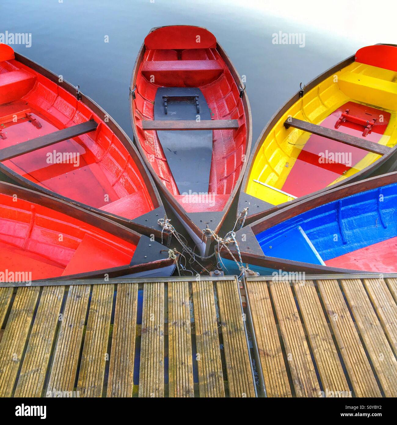 Five colourful rowing boats moored in a fan pattern Stock Photo