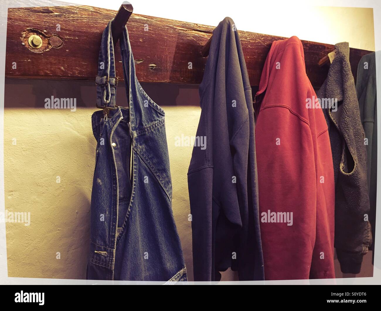 Hanging jackets and overalls. Hanging on wall mounted pegs Stock Photo
