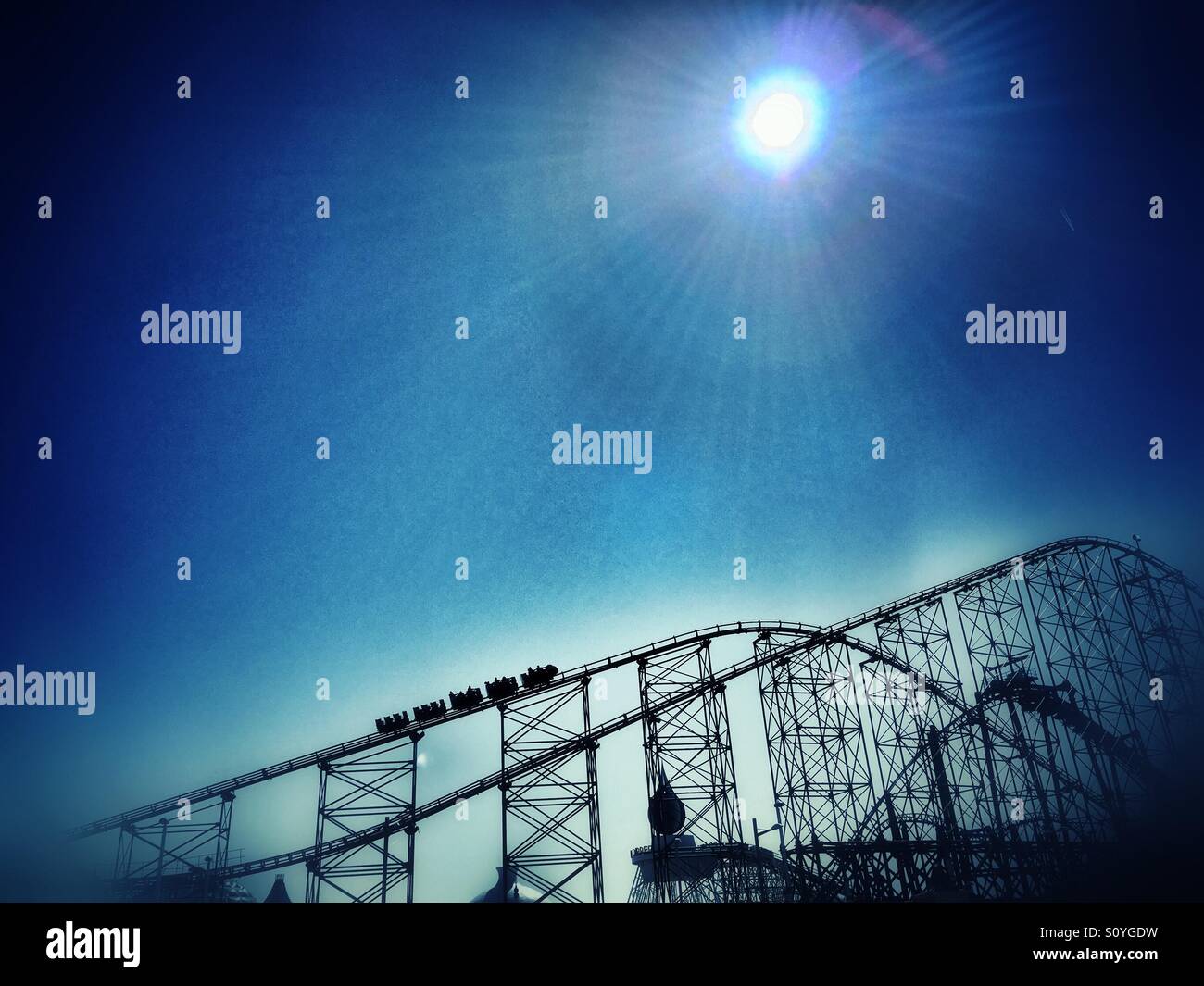 The Big One roller coaster on Blackpool Pleasure Beach in silhouette against a bright sun - Smartphone Captured Stock Image