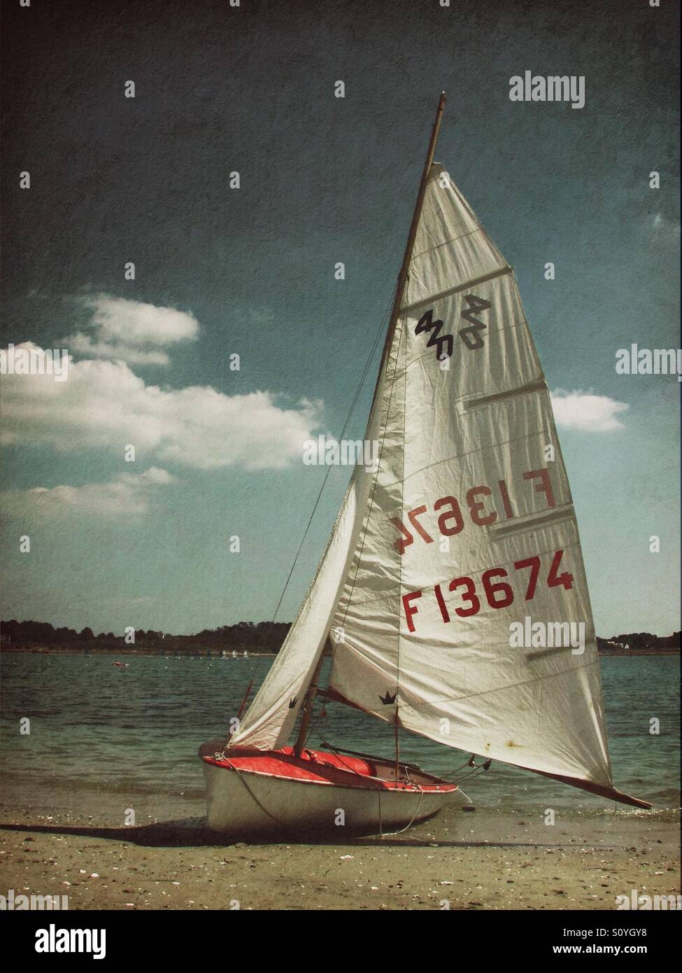 Red and white sailing boat on beach Stock Photo - Alamy