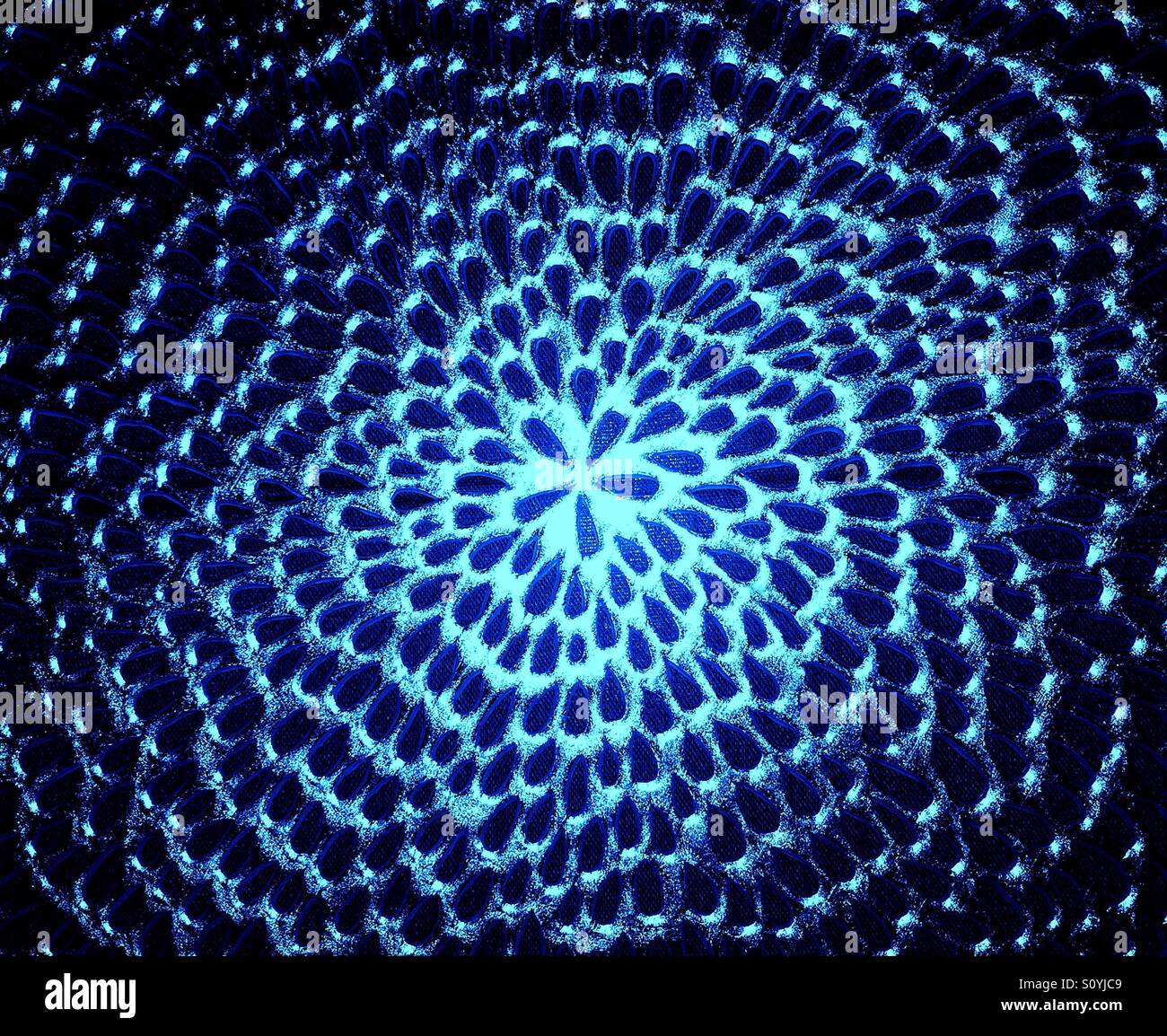 Abstract starburst pattern created by a metallic table placemat in blue tones - Smartphone Captured Stock Image