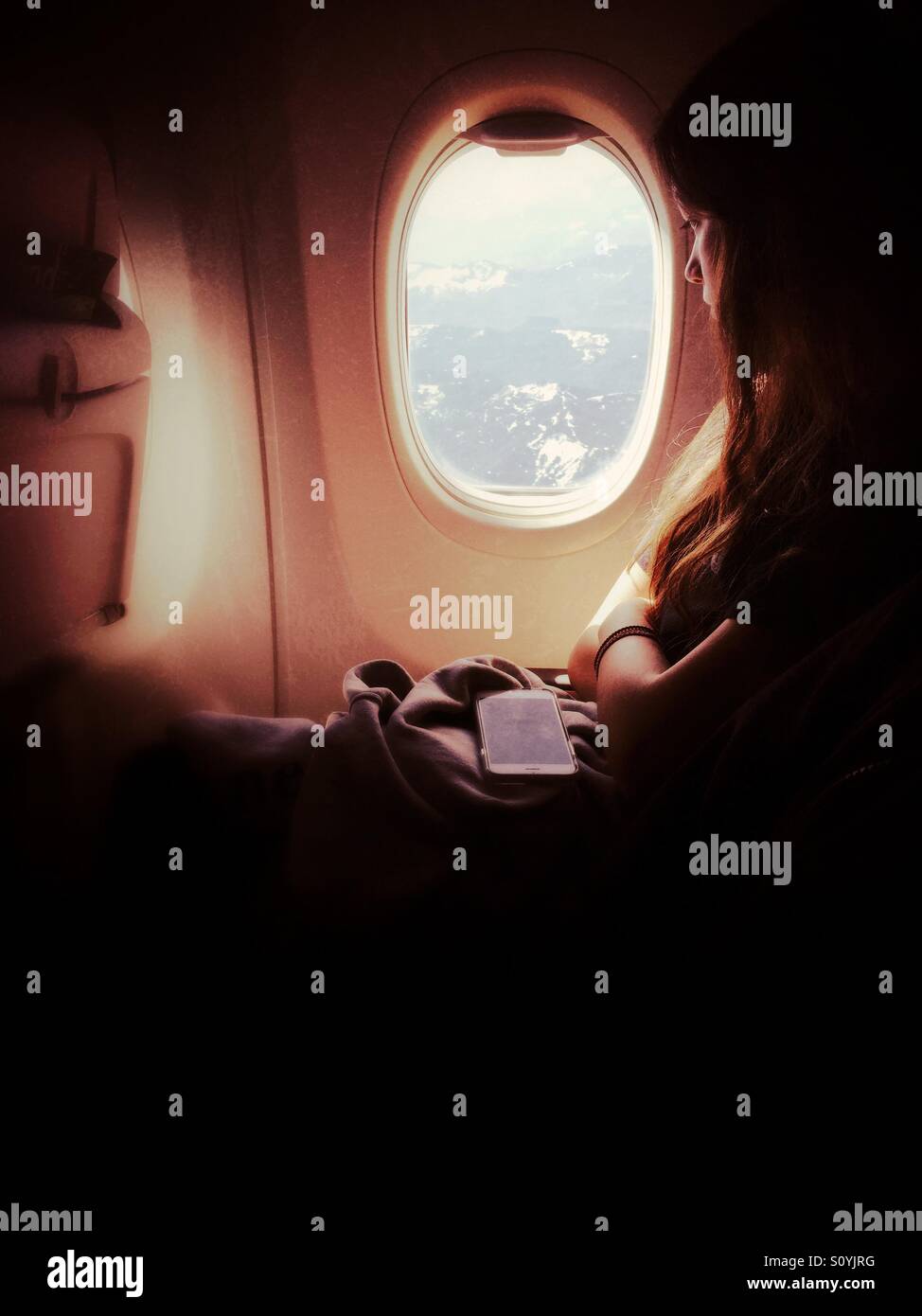 Girl looking in the window of airplane - Smartphone Captured Stock Image