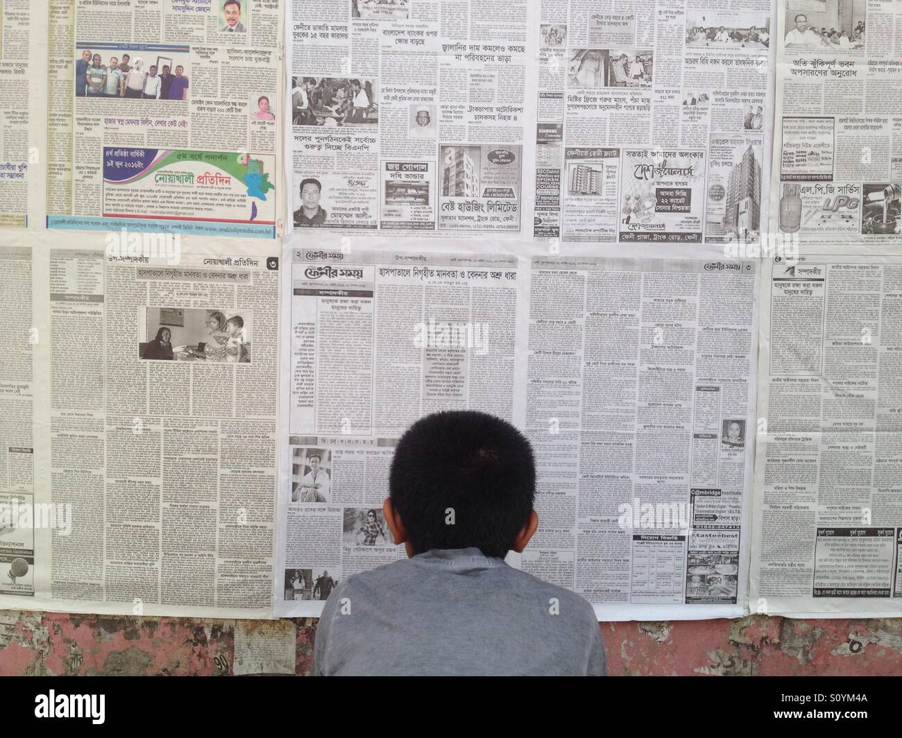 A Bangladeshi boy reads wall newspaper at Dhaka Stock Photo Alamy