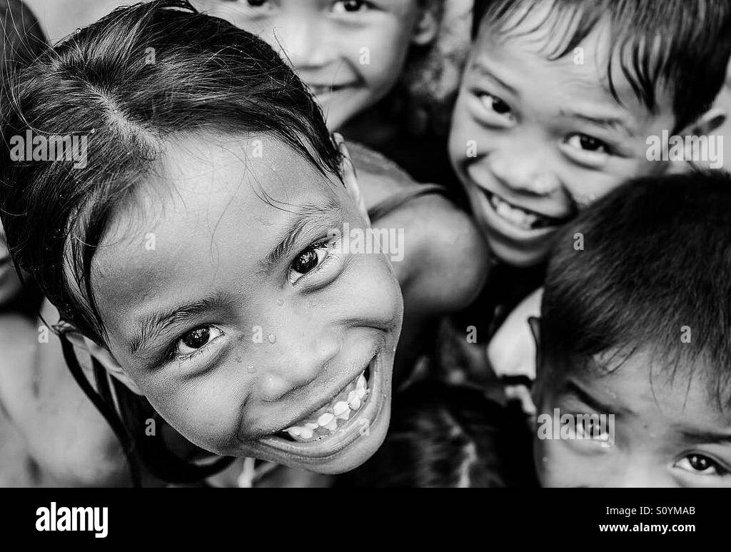 Smiling faces of children in black and white Stock Photo