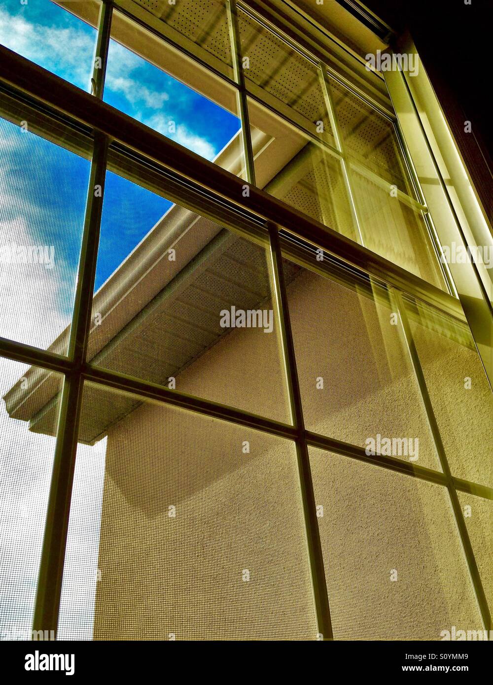 Window view with blue sky and building detail - Smartphone Captured Stock Image