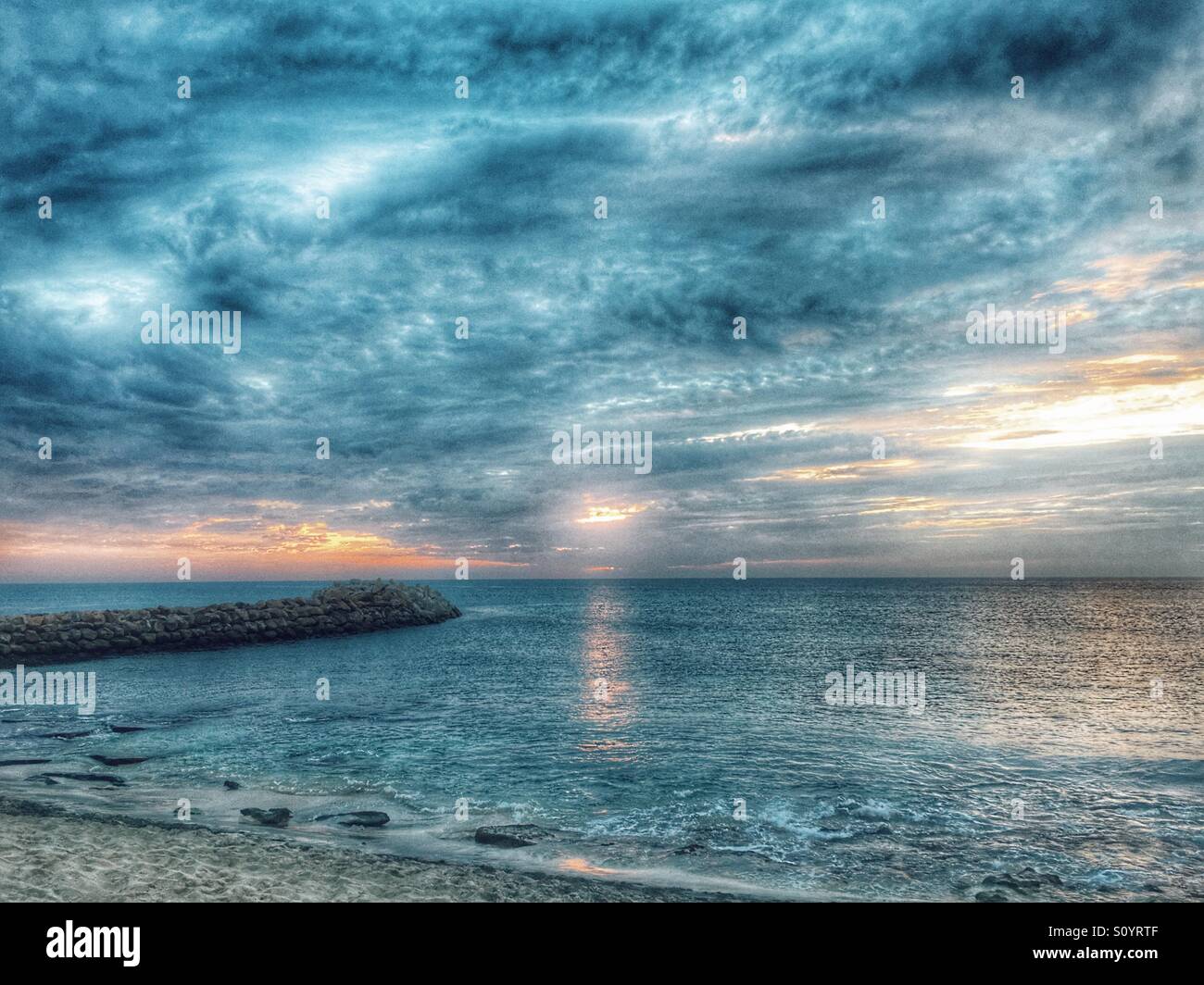 Blue and orange cloud colours during sunset over the ocean - Smartphone Captured Stock Image