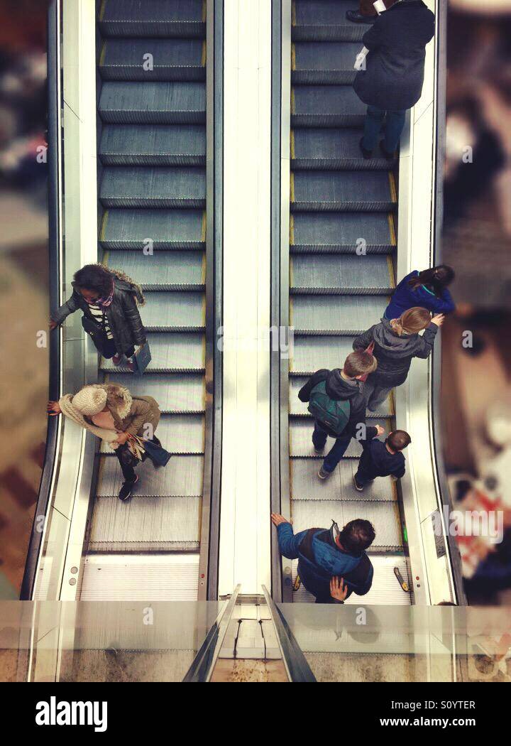 People going up and down a mechanical escalator - Smartphone Captured Stock Image