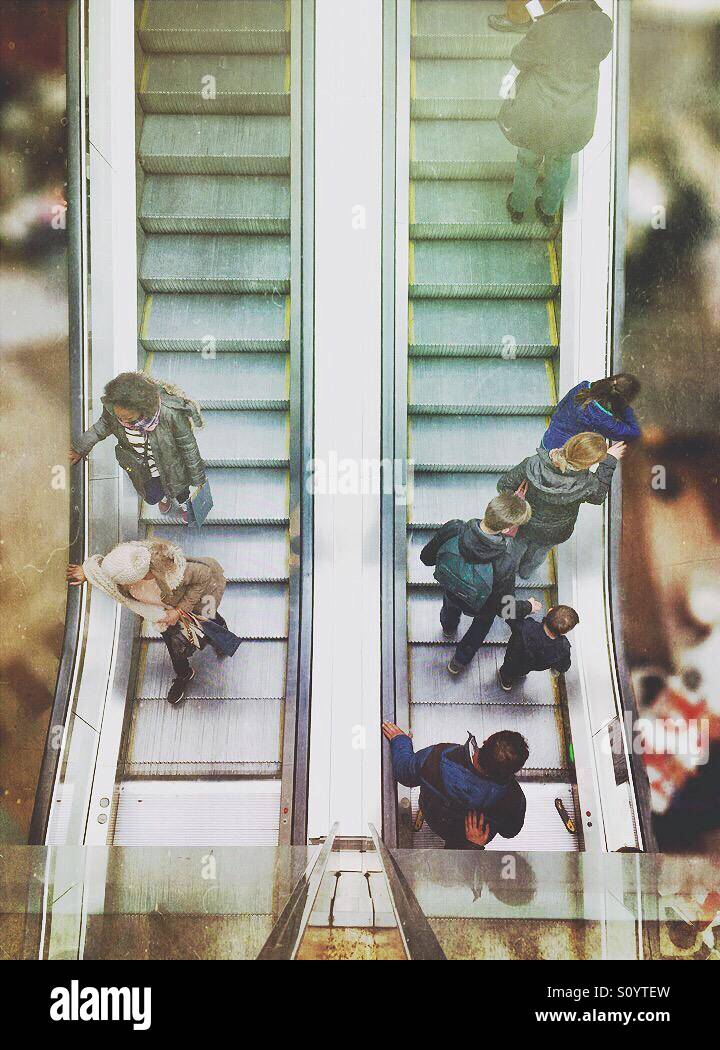 People going up and down a mechanical escalator - Smartphone Captured Stock Image