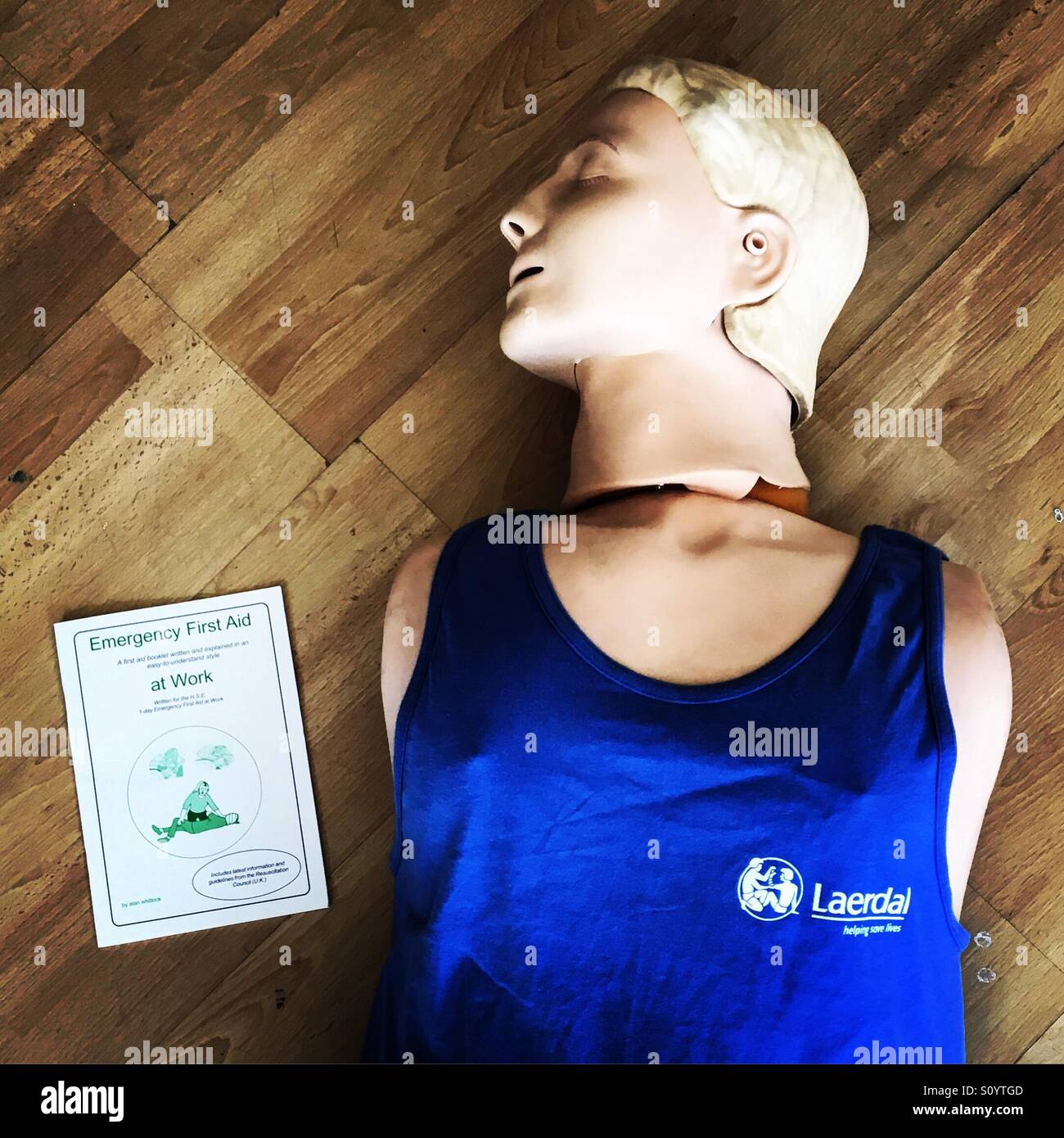 CPR practice mannequin and first aid course booklet - Smartphone Captured Stock Image