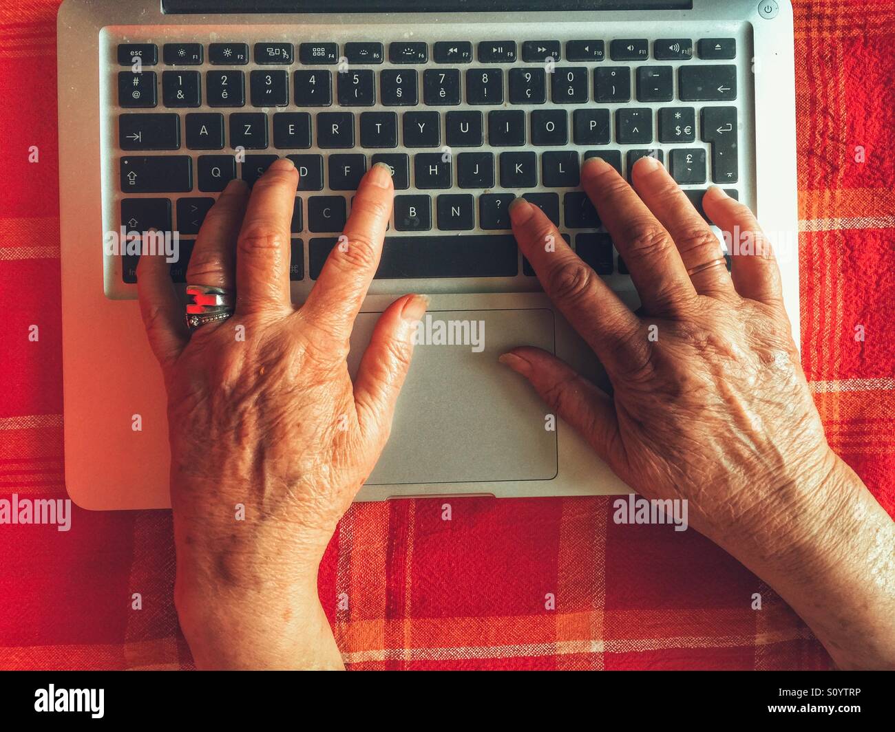 Senior woman typing on computer - Smartphone Captured Stock Image