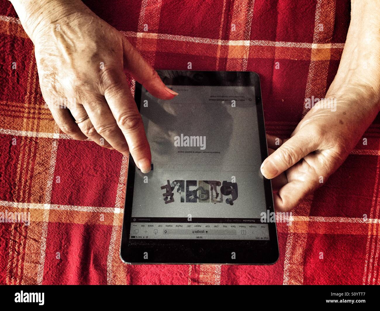 Old woman using tablet - Smartphone Captured Stock Image